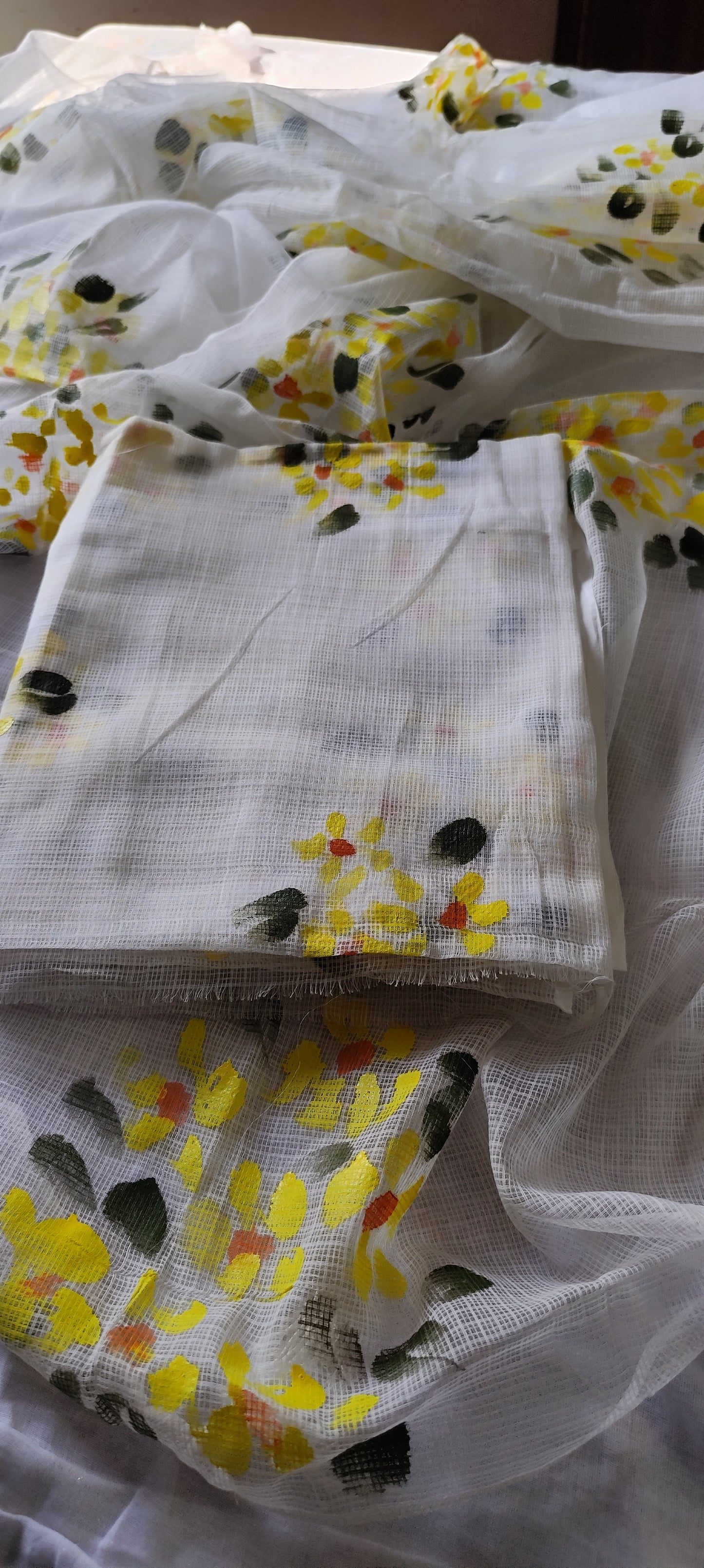 Hand-painted white pure kota doria suit with yellow flowers.