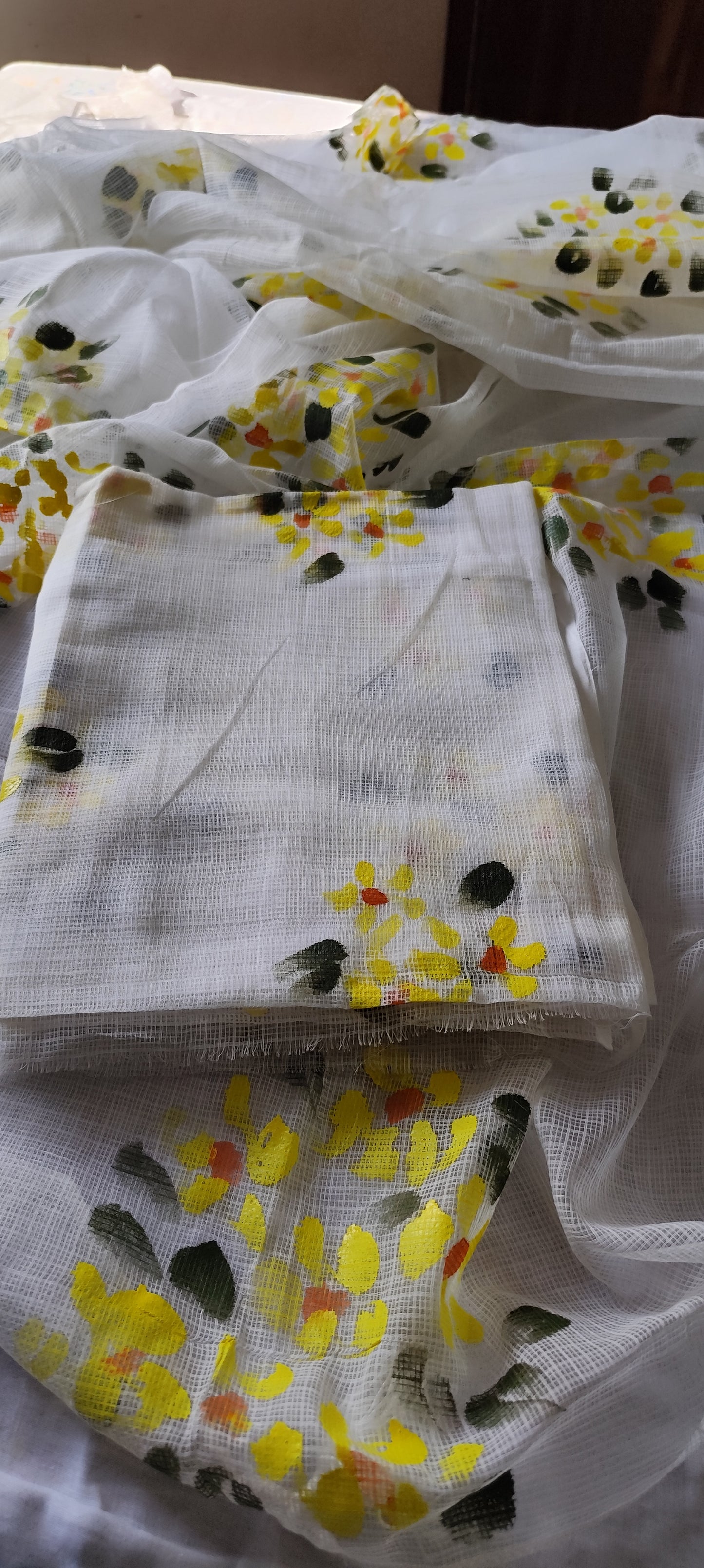 Hand-painted white pure kota doria suit with yellow flowers.